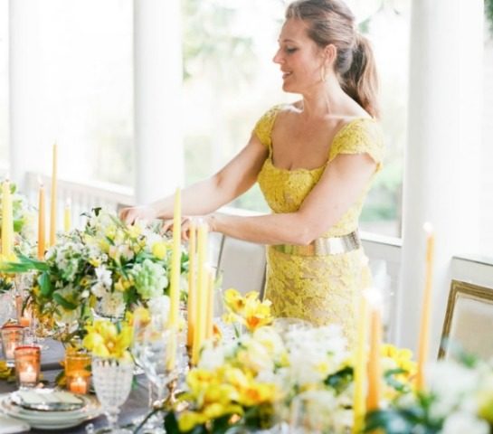 A woman arranging flowers at a table