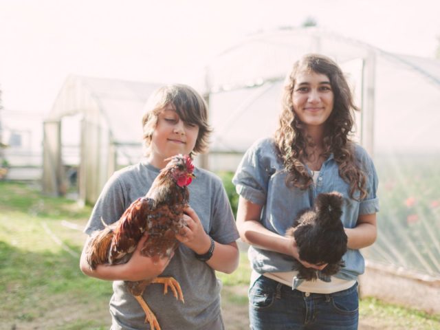 Elora and Jasper Benzakein holding chickens