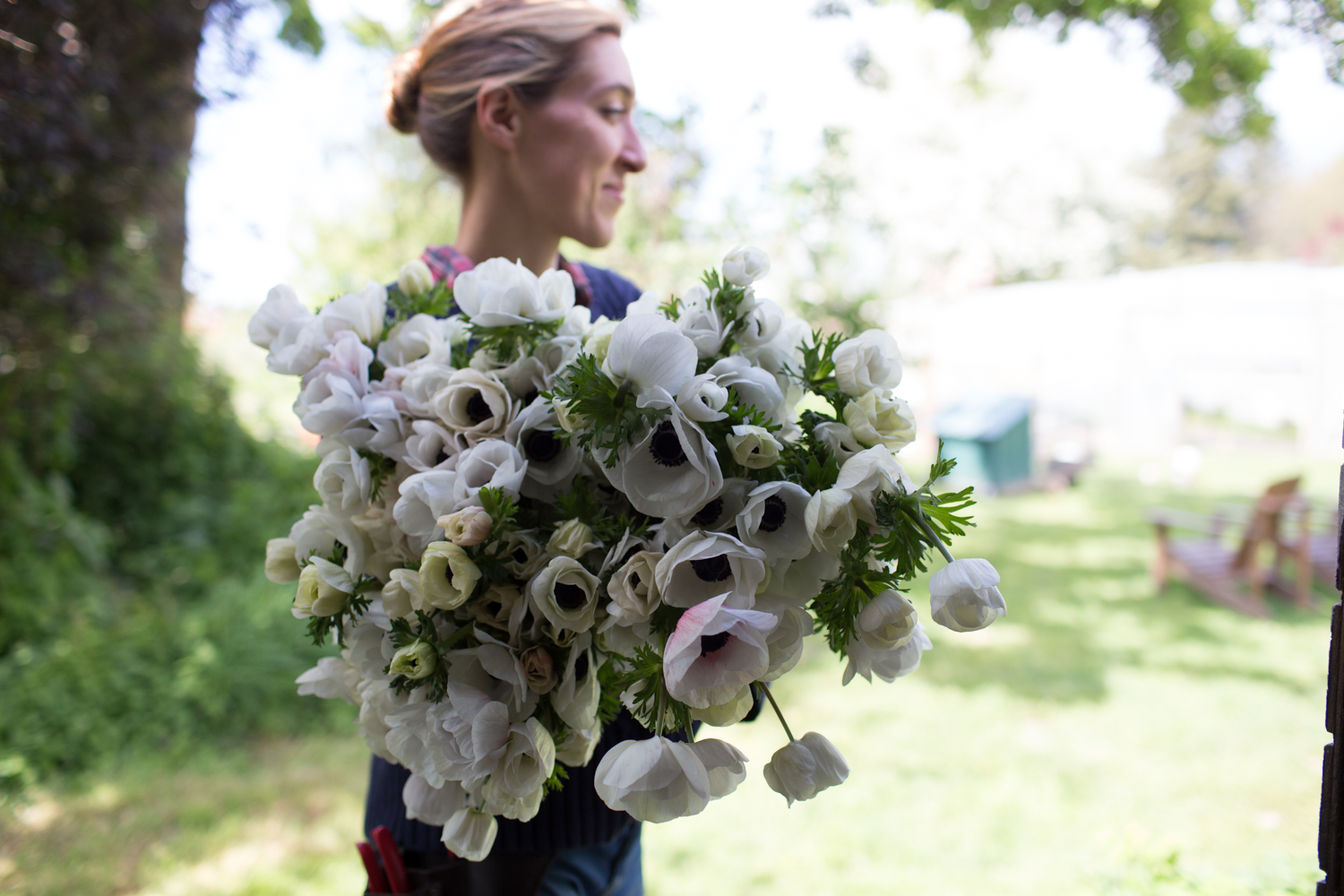 Erin Benzakein holding a large bouquet of black and white anemones